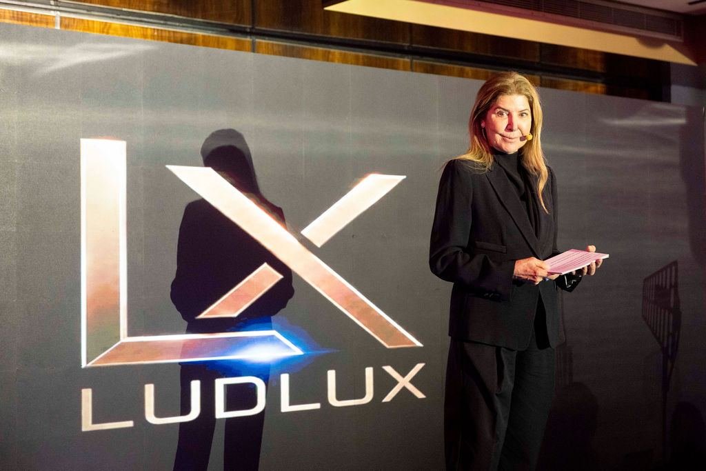 Palestrante no palco com a marca LudLux projetada ao fundo