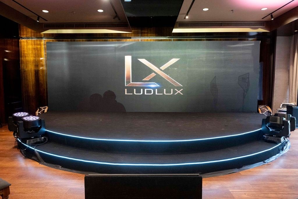 Palco da experiência com a marca LudLux no painel