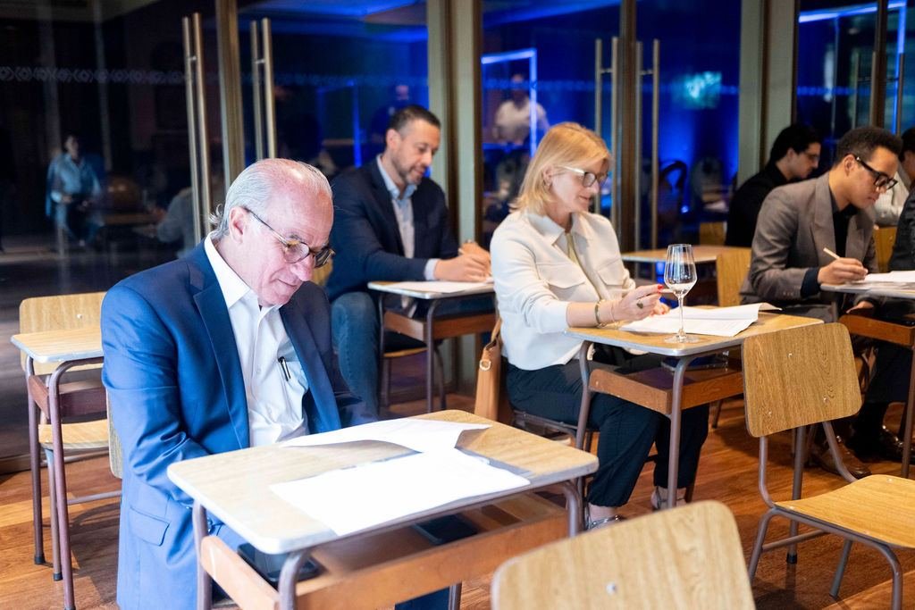 Participantes registrando suas escolhas nas mesas de trabalho