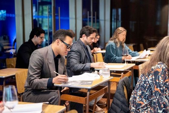 Participantes registrando decisões nas mesas de trabalho